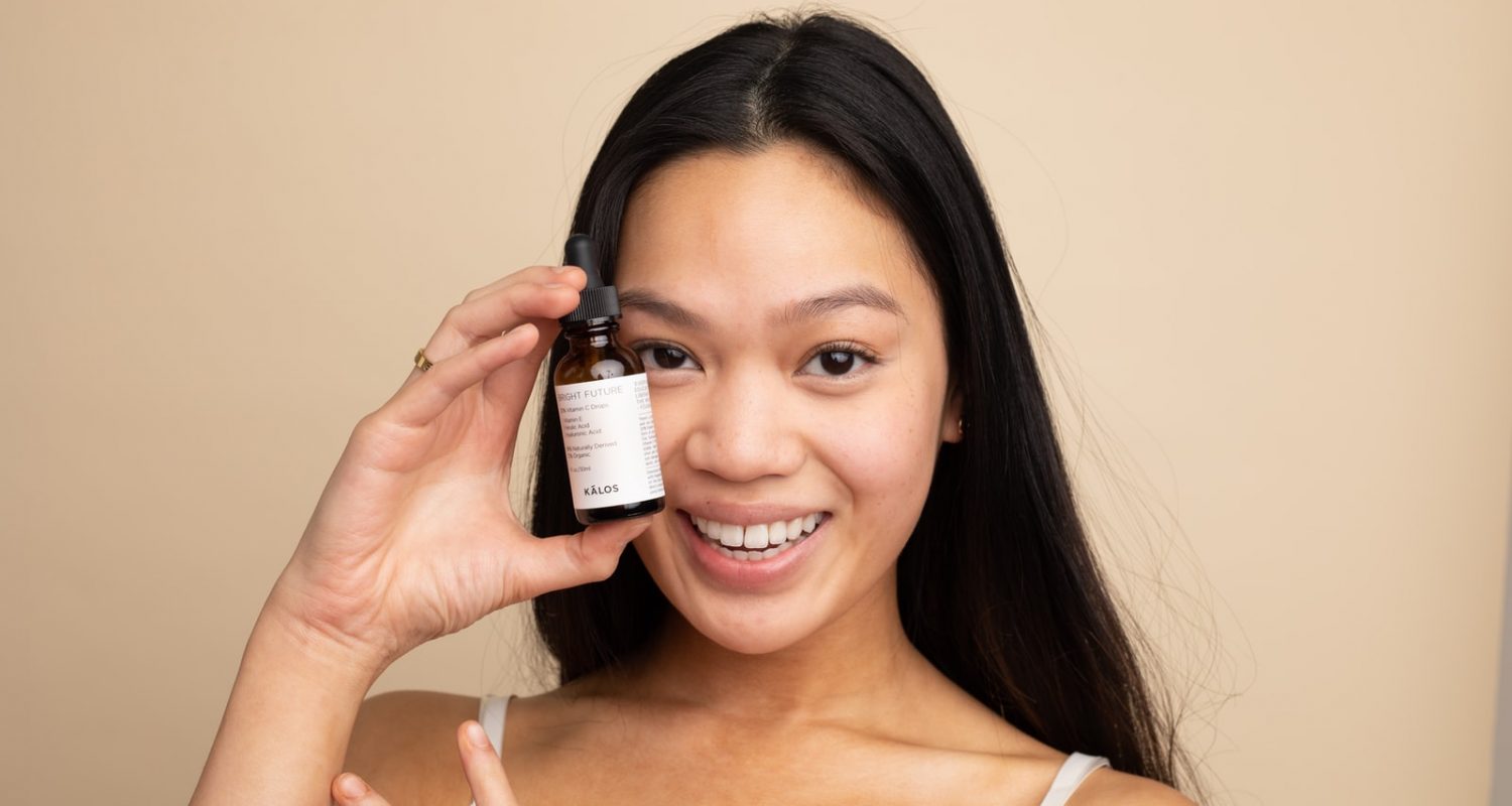 woman in white tank top holding white labeled bottle